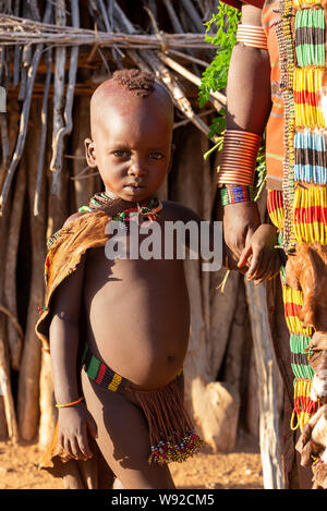 Turmi, Omo River Valley, Etiopia - 10 Maggio 2019: Ritratto di Hamar bambini nel villaggio. Gli Hamer sono una tribù primitiva e le donne hanno molti dec Foto Stock