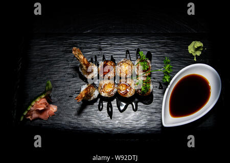 Una gustosa otto pezzi tempura hosomaki rotoli spruzzata con salsa teriyaki Foto Stock