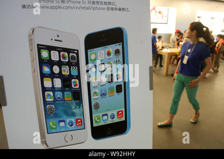 Un dipendente cinese passeggiate passato un annuncio pubblicitario per il nuovo iPhone 5S e iPhone 5c di smartphone Apple presso un Apple Store in Cina a Shanghai, 17 Settembre Foto Stock