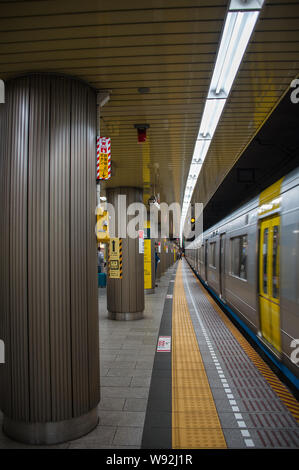 Tokyo, Giappone - Aprile 2019: un treno della metropolitana in movimento lungo una luminosa piattaforma a un giapponese di Stazione della Metropolitana. Foto Stock