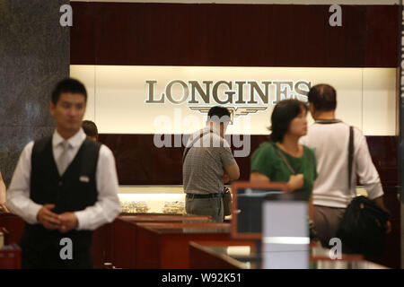 --FILE--clienti negozio di orologi in un negozio di Swiss watch brand Longines in Cina a Shanghai, 28 maggio 2013. Switzerlands le esportazioni di orologi a principale Foto Stock