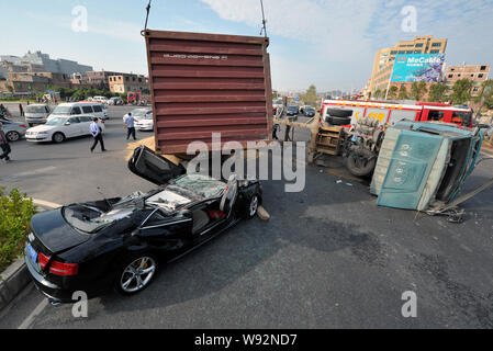 Un contenitore capovolto viene sollevato dopo averlo schiacciato e appiattito un Audi S5 in cui un autista e un altro passeggero sono intrappolati sulla 324 Compit Foto Stock