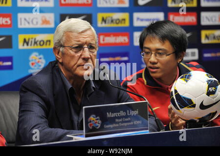 Capo allenatore Marcello Lippi, sinistra, di porcellane Guangzhou Evergrande ascolta una domanda nel corso di una conferenza stampa per l'AFC Champions League 2013 in G Foto Stock