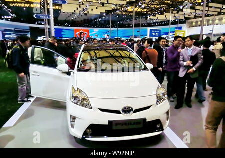 --FILE--i visitatori guardare una Toyota Prius durante il XV Shanghai industria automobilistica internazionale mostra, noto come auto Shanghai 2013, Shangha Foto Stock