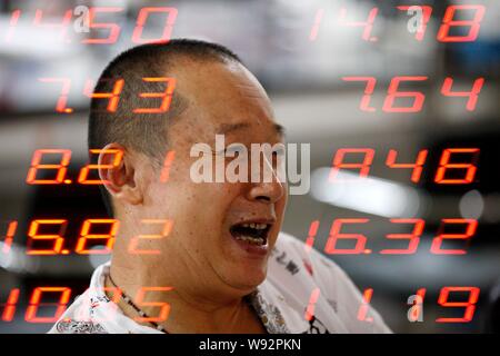 In questo multi-immagine di esposizione, un investitore cinese sorride come egli guarda i prezzi delle azioni (rosso per il prezzo in salita) in corrispondenza di un magazzino casa di brokeraggio in Huaibei Foto Stock