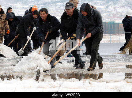 Lavoratori cinesi pala neve dalla pista di Kunming Changshui Aeroporto Internazionale nella città di Kunming, southwest Chinas nella provincia dello Yunnan, 16 Decem Foto Stock