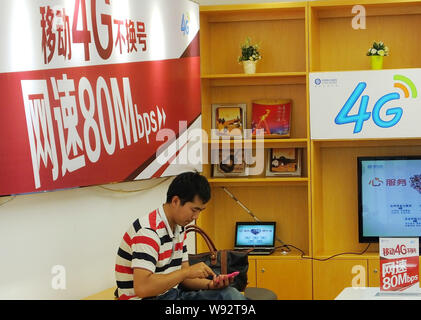 --FILE--un cliente tenta di eseguire 4G servizi presso una filiale della China Mobile nella città di Guangzhou, sud Chinas nella provincia di Guangdong, 31 ottobre 2013. In eme Foto Stock