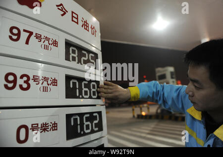 Un lavoratore cinese aggiorna i prezzi del carburante in corrispondenza di una stazione di benzina della CNPC (China National Petroleum Corporation), genitore di PetroChina, di Nanchang City, est Chi Foto Stock