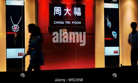 --FILE--pedoni a piedi passato un ramo di Chow Tai Fook in Cina a Shanghai, 12 maggio 2013. Presso i mondi più grande rivenditore di gioielli dalle vendite, caduta di g Foto Stock