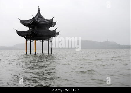 Il famoso Jixian Pavilion è parzialmente sommerso dall'acqua sulla banca del allagato Lago Ovest dopo le forti piogge hanno causato dal tifone Fitow in Hangzhou Foto Stock