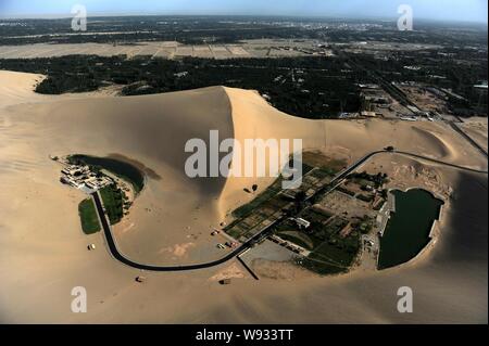 --FILE--Vista aerea di Mezzaluna Lago, sinistra, noto anche come Yueyaquan, circondato da Singing-Sand dune nel deserto in Dunhuang, northwes Foto Stock