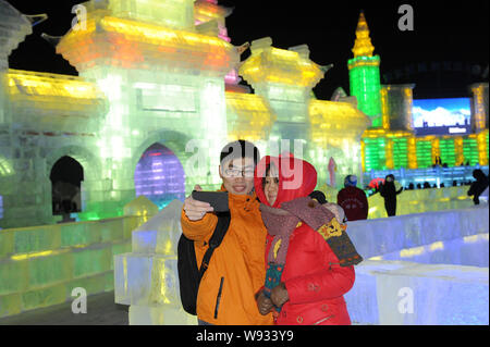 Una coppia giovane prende selfies davanti a sculture di ghiaccio al XV di Harbin ed al Mondo del Ghiaccio e della neve nella città di Harbin, nordest Chinas Provincia di Heilongjiang, Foto Stock