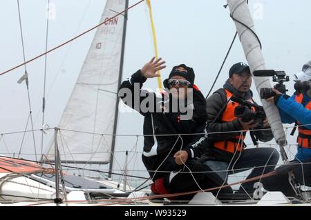 Chinas Guo Chuan (prima a sinistra) onde come la sua barca a vela che arrivano a una porta nella città di Qingdao, est Chinas Provincia di Shandong, 5 aprile 2013. Guo Chuan saile Foto Stock