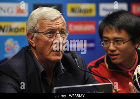 Capo allenatore Marcello Lippi, sinistra, di porcellane Guangzhou Evergrande ascolta una domanda nel corso di una conferenza stampa per l'AFC Champions League 2013 in G Foto Stock