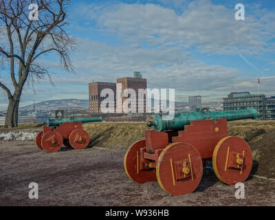 La Fortezza di Akershus, Oslo, Norvegia - 14 Marzo 2016: cannoni antichi oltre le torri del castello che si affaccia il Municipio di Oslo Foto Stock