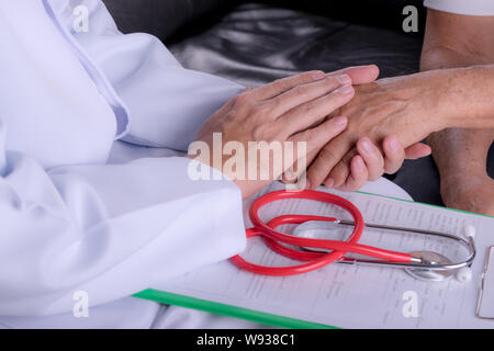 Medico medico tenendo la mano con il vecchio uomo di dare assistenza. Il morbo di Parkinson e di Alzheimer senior maschili paziente anziano. Assistenza sanitaria e assistenza medica. Foto Stock