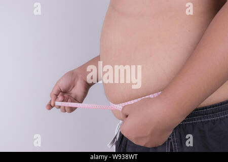 Fat Man check out il suo corpo grasso con nastro di misurazione. obesità e health care concetto. Foto Stock