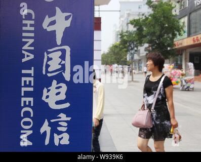 --FILE--pedoni a piedi passato una segnaletica di China Telecom in Nantong, est Chinas provincia dello Jiangsu, 7 settembre 2013. China Telecom strategica inchiostrato c Foto Stock