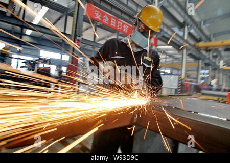 --FILE--un lavoratore cinese lucidanti prodotti di acciaio presso lo stabilimento di Nantong Guosheng macchinari & Power-Generating Group Co., Ltd. nella città di Nantong, EST C Foto Stock