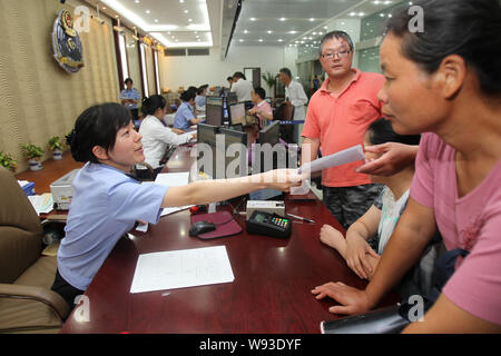 --FILE--femmina di un funzionario di polizia serve ai cittadini presso la reception dell' amministrazione Exit-Entry distacco di Nantong Public Security Bureau in Foto Stock