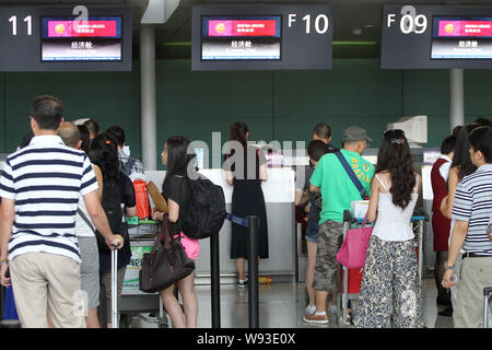 --FILE--i passeggeri in coda per il check-in presso il contatore di Juneyao Airlines in Cina a Shanghai, 13 luglio 2013. Un consorzio di investitori guidato da Juneya Foto Stock