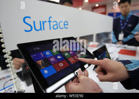 --FILE--un acquirente cinese tenta di eseguire un Microsoft Surface Pro Tablet PC in un home appliances store in Cina a Shanghai, 3 aprile 2013. Microsoft Corp.s Foto Stock