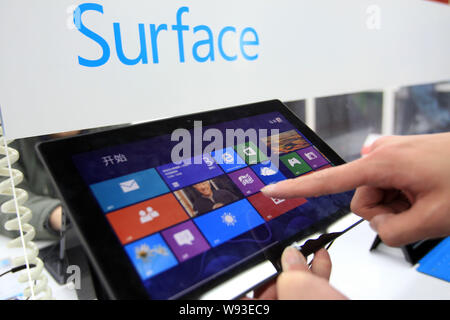 --FILE--un acquirente cinese tenta di eseguire un Microsoft Surface Pro Tablet PC in un home appliances store in Cina a Shanghai, 3 aprile 2013. Microsoft Corp.s Foto Stock