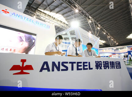 --FILE--dipendenti cinesi parlare allo stand di Anshan Ferro e acciaio (Gruppo) Corporation, noto anche come ANSTEEL, durante una mostra a Shanghai, Chi Foto Stock