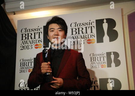 --FILE--pianista cinese Lang Lang pone con il suo trofeo dopo aver vinto il classico BRIT Awards alla Royal Albert Hall di Londra, Regno Unito, 2 ottobre 2013. Foto Stock