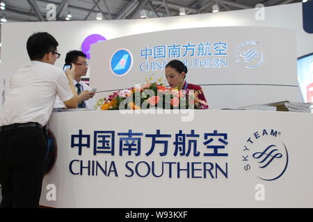 --FILE--dipendenti cinesi parlare allo stand di China Southern Airlines durante una mostra a Chongqing Cina, 16 maggio 2013. China Southern Airline Foto Stock