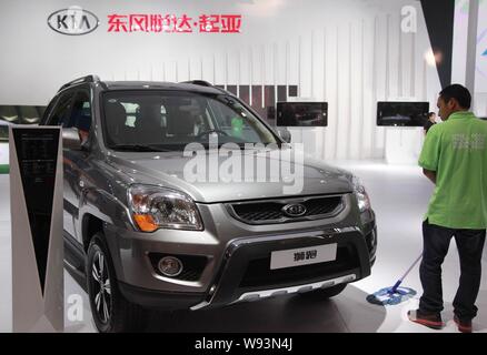 --FILE--un lavoratore pulisce il pavimento presso lo stand di Kia durante il sesto Nanjing International Auto Fair, nella città di Nanjing East Chinas provincia dello Jiangsu, 2 Foto Stock