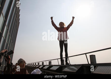 Il francese Spiderman Alain Robert celebra dopo aver terminato la scalata di 288-metro-alto orizzonte Shimao edificio centrale nella città di Shaoxing, est Chinas Zhej Foto Stock