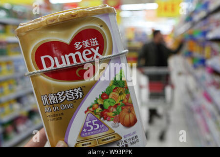 --FILE--un cliente negozi per una lattina di Dumex baby formula di Danone in un supermercato in Ganyu county, est Chinas provincia dello Jiangsu, 20 dicembre 2013. Foto Stock