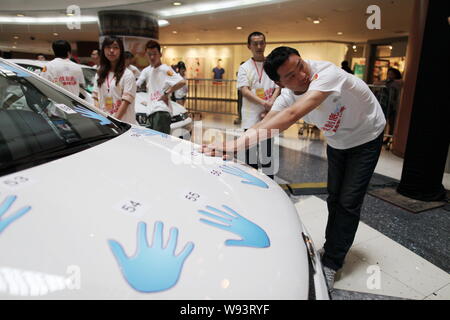 Concorrenti cinesi tenere le mani sulla Volkswagen Polo GTI auto durante una mano-su-auto competizione endurance a Super Brand Mall in Lujiazui Financ Foto Stock