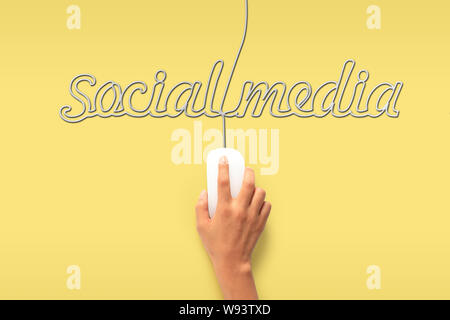 Mouse del computer con il suo filo che fa una parola social media Foto Stock