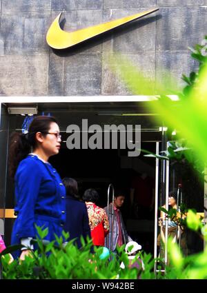 --FILE--un pedone cammina davanti a un negozio di abbigliamento sportivo Nike in Yichang city, porcellane centrale provincia di Hubei, 20 marzo 2013. Essa è stata lo scorso giugno che Nike Foto Stock