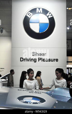 --FILE--dipendenti cinesi parlare presso lo stand della BMW durante il XV Shanghai industria automobilistica internazionale mostra, noto come auto Shanghai 2013, Foto Stock