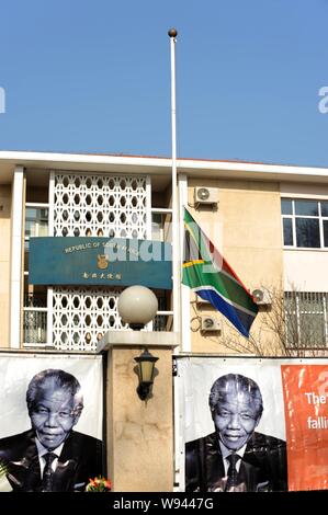 Foto di ex presidente sudafricano Nelson Mandela sono visualizzati come il South African National bandiera sventola a metà il montante al South African Em Foto Stock