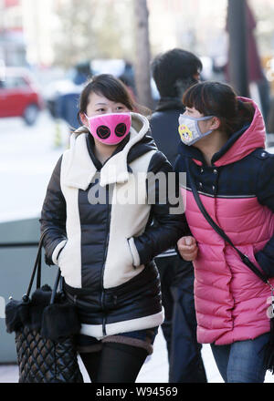 Pedoni indossando maschere viso a piedi sulla strada dello shopping di Wangfujing di Pechino, Cina, 2 gennaio 2013. Un top medico ha sostenuto che la denominazione una cronica Foto Stock