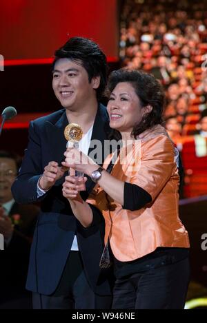 Pianista cinese Lang Lang, sinistra, pone con sua madre mentre egli riceve il trofeo di portare con voi il fascino al premio del mondo durante il 2012-2013 si B Foto Stock