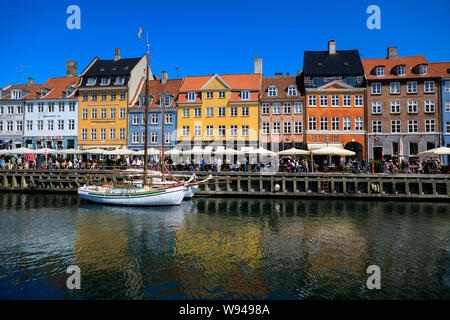 Copenhagen, Danimarca - 11 Luglio 2019: folla di persone sono in appoggio sul lungomare di Nyhavn canal in estate Foto Stock