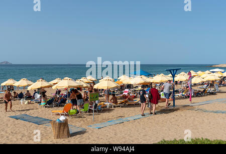 Iraklion, Creta, Grecia. Giugno 2019. Acapulco Beach si trova vicino all'aeroporto Iraklion. I turisti a prendere il sole Foto Stock