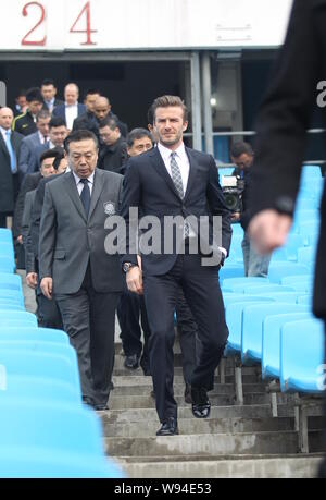 Inglese soccer superstar David Beckham, anteriore, è seguita da funzionari cinesi durante la sua visita alla stadio dei lavoratori di Beijing, Cina, 21 marzo 20 Foto Stock