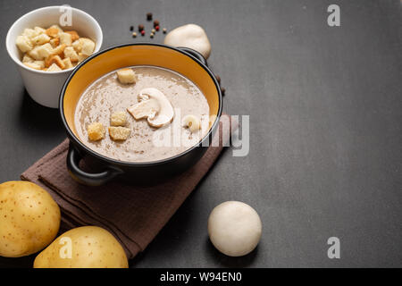Deliziosi funghi champignon minestra di crema su sfondo scuro. Messa a fuoco selettiva Foto Stock