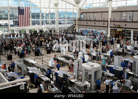 Controlli di sicurezza in aeroporto TSA checkpoint all'Aeroporto Internazionale di Denver, CO con linee di viaggiatori Foto Stock