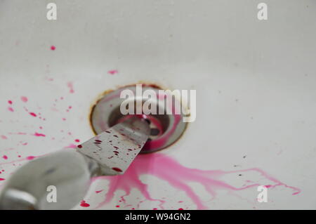 Coltello con schizzi di sangue su bianco ceramica bagno lavandino Foto Stock