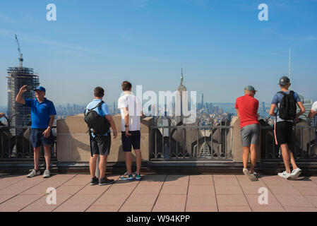 Turismo USA, visualizzare dei maschi di turisti in cerca su Midtown Manhattan dal Rockefeller Center Observation Deck, New York City, Stati Uniti d'America Foto Stock