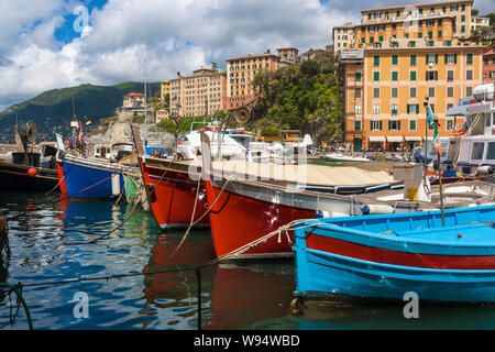 Vista della città di Camogli sulla Riviera Ligure in Italia con il suo porto. In primo piano il tipico colorate barche da pesca Foto Stock