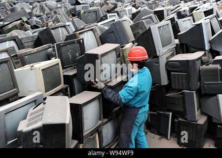 Un lavoratore cinese accumula scartato i televisori e altri dispositivi elettronici in corrispondenza di una stazione di riciclo di Chengdu, southwest Chinas nella provincia di Sichuan, 6 marzo 201 Foto Stock