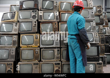 Un lavoratore cinese accumula scartato i televisori e altri dispositivi elettronici in corrispondenza di una stazione di riciclo di Chengdu, southwest Chinas nella provincia di Sichuan, 6 marzo 201 Foto Stock